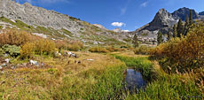 After the stark, rugged pass, the trail descends into a lush valley