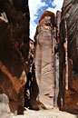 A towering monolith at the end of an open courtyard guards the tiny entrance to continue.